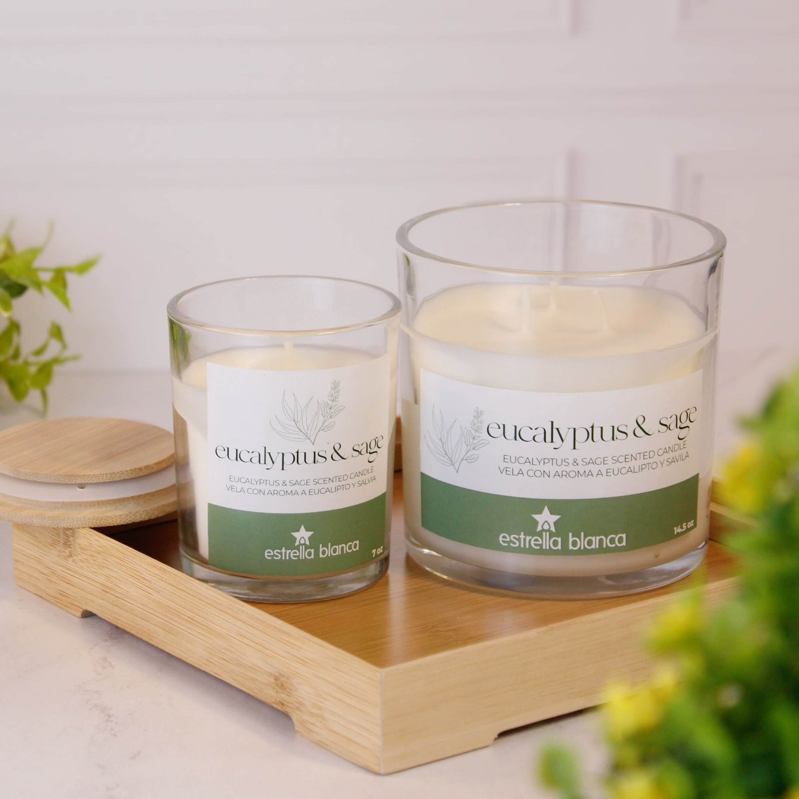 Elegant scented candle beside flowers and home decor